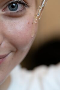 Gros plan sur l'application d'un sérum sur le visage, illustration des soins de qualité de peau